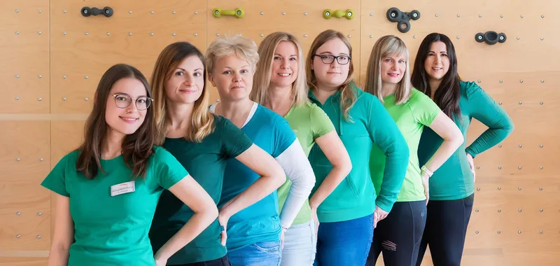 Das Team der Praxis Löbau vor der Kletterwand in den Therapieräumen